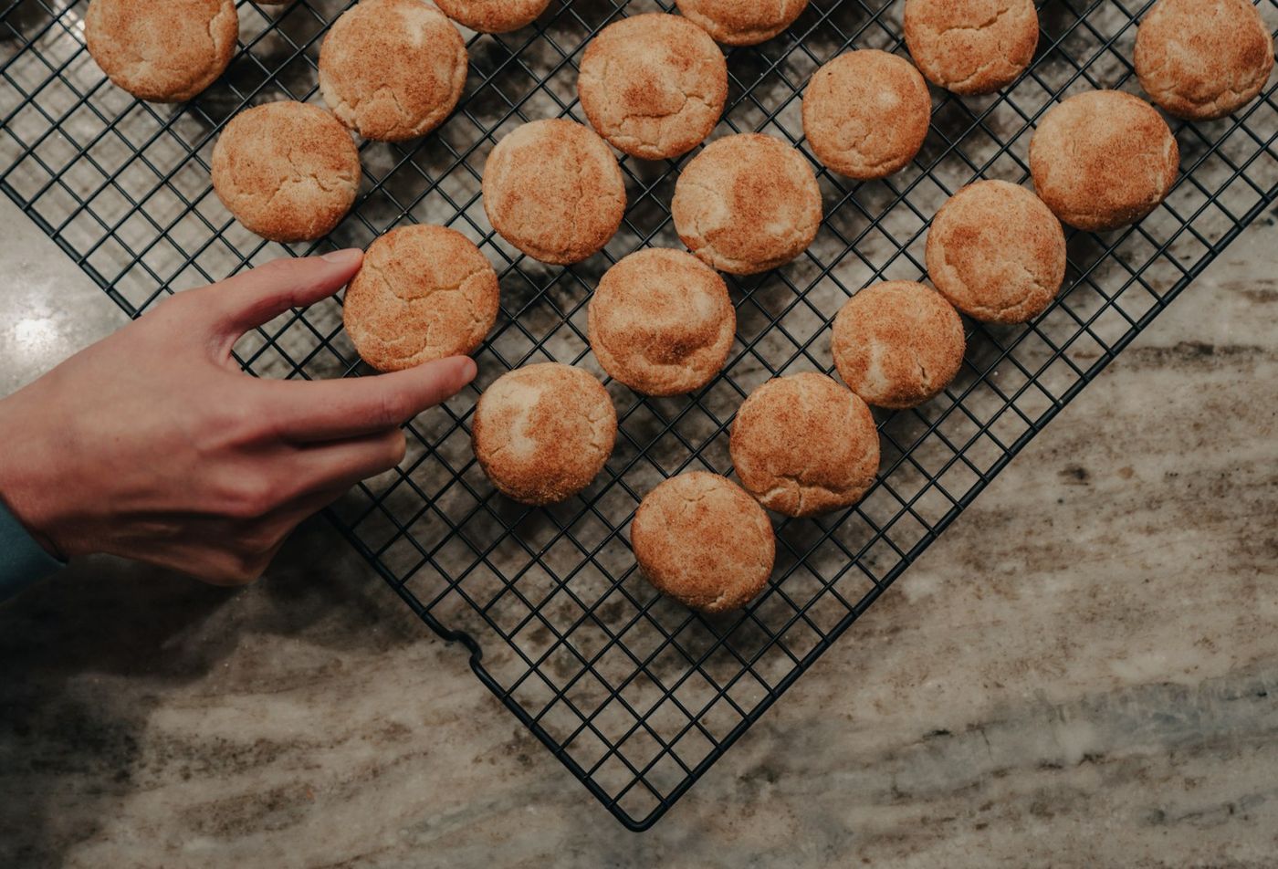 Rows of crackle-topped ginger cookies on a cooling rack