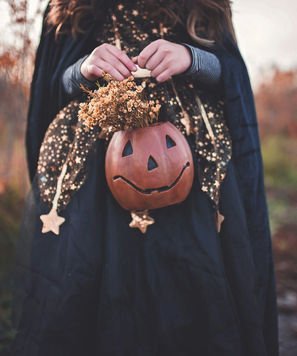A witch costume with a pumpkin pail