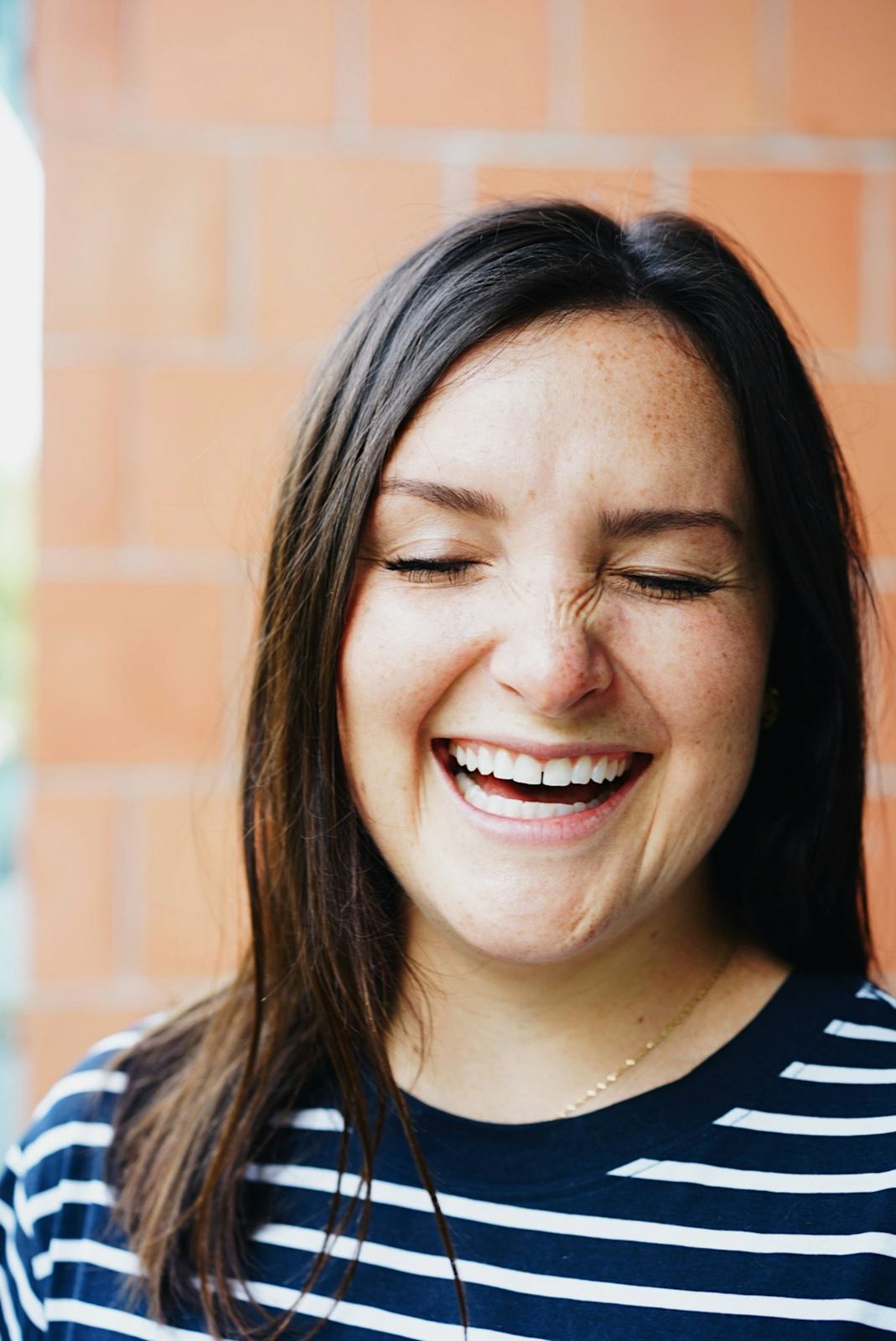 A young woman laughing with a natural smile