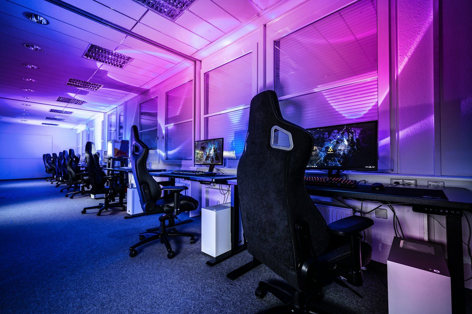 A blue-lit training room with gaming chairs