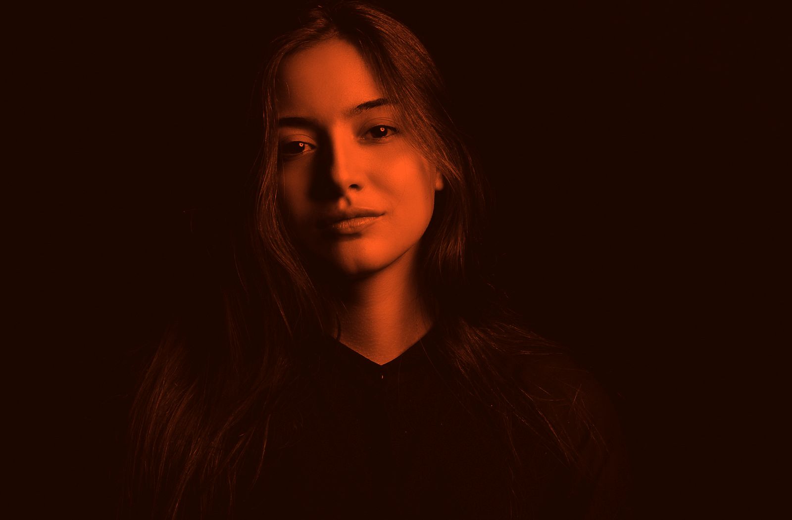 A faculty portrait in orange duotone