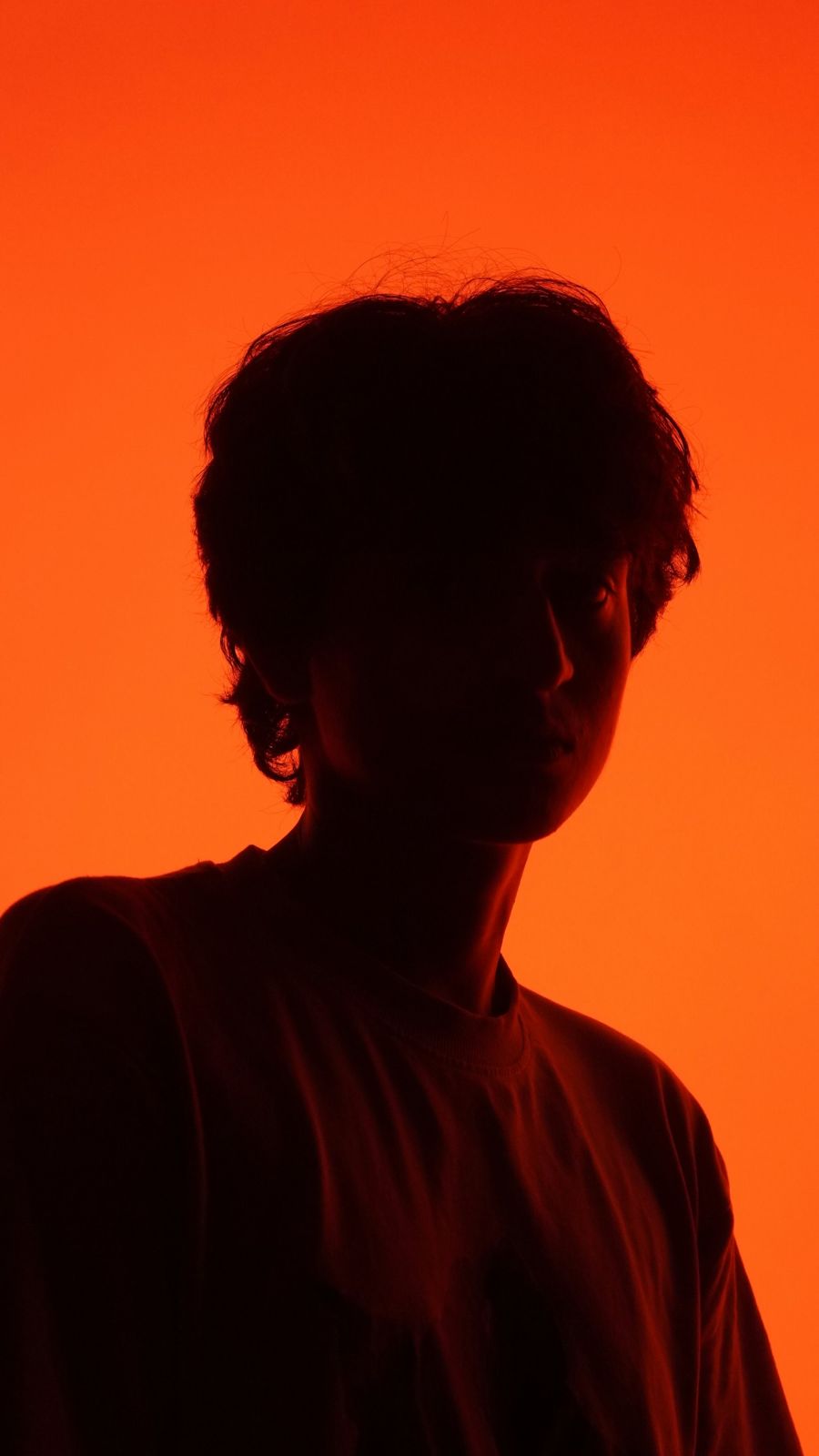 A silhouetted portrait against orange