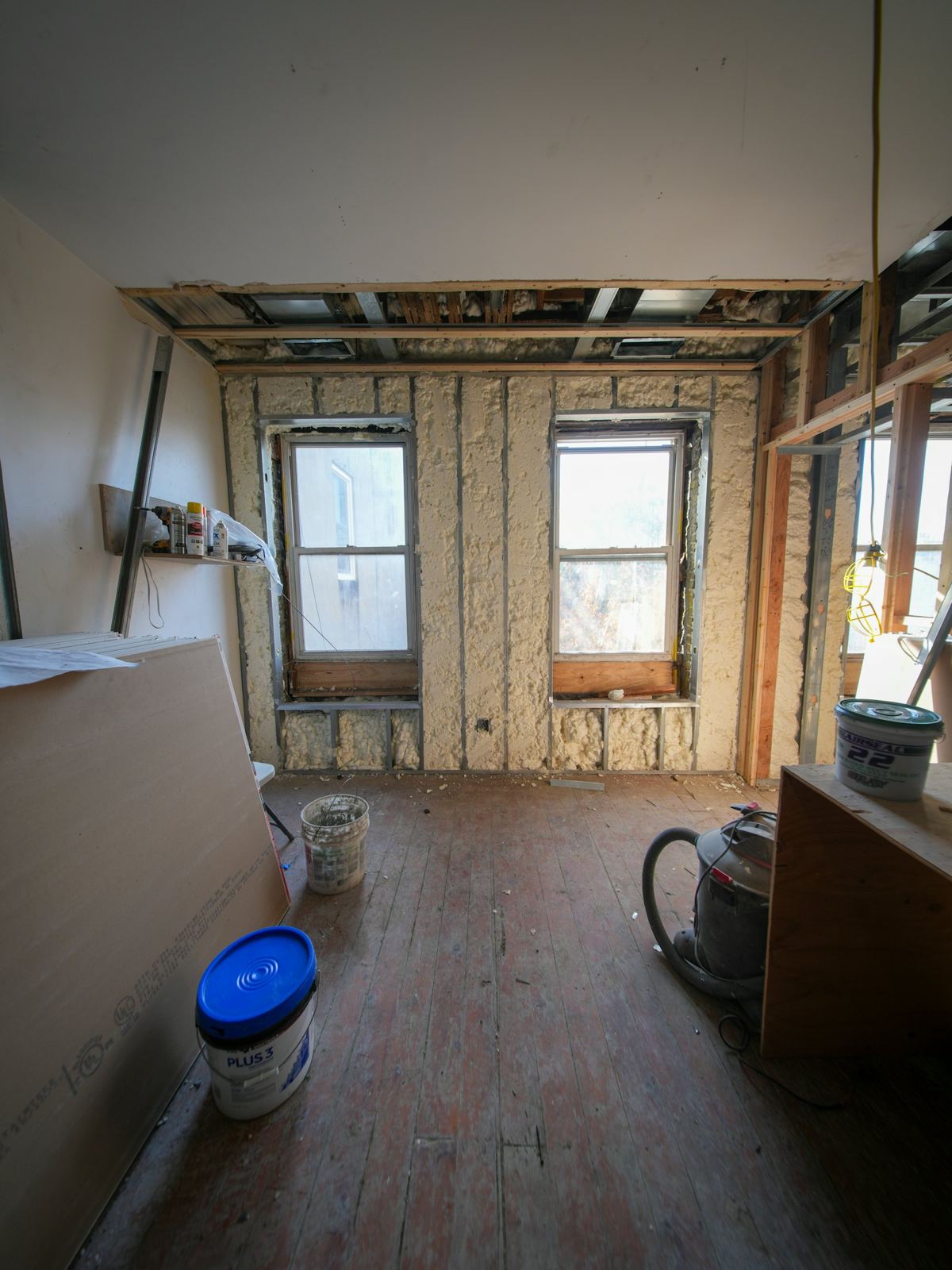 A gutted room with open stud walls