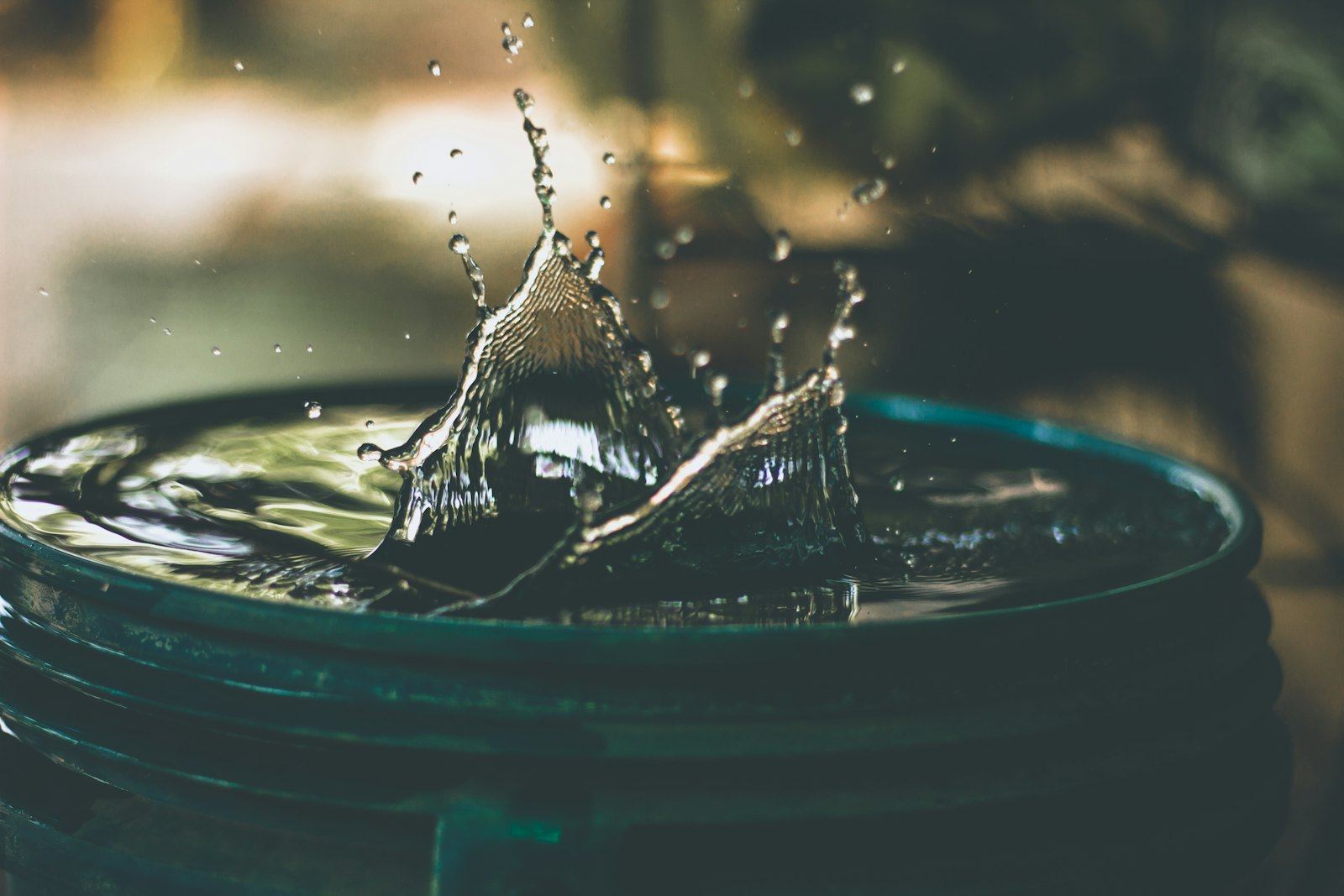 Water splashing into a full bucket