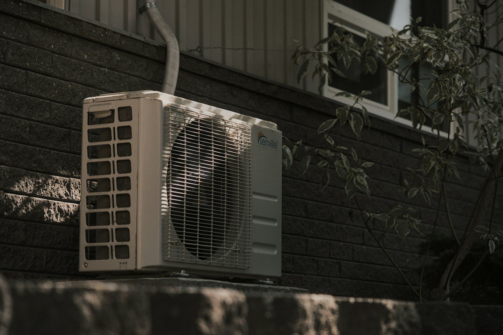 An outdoor air-conditioning unit against brick