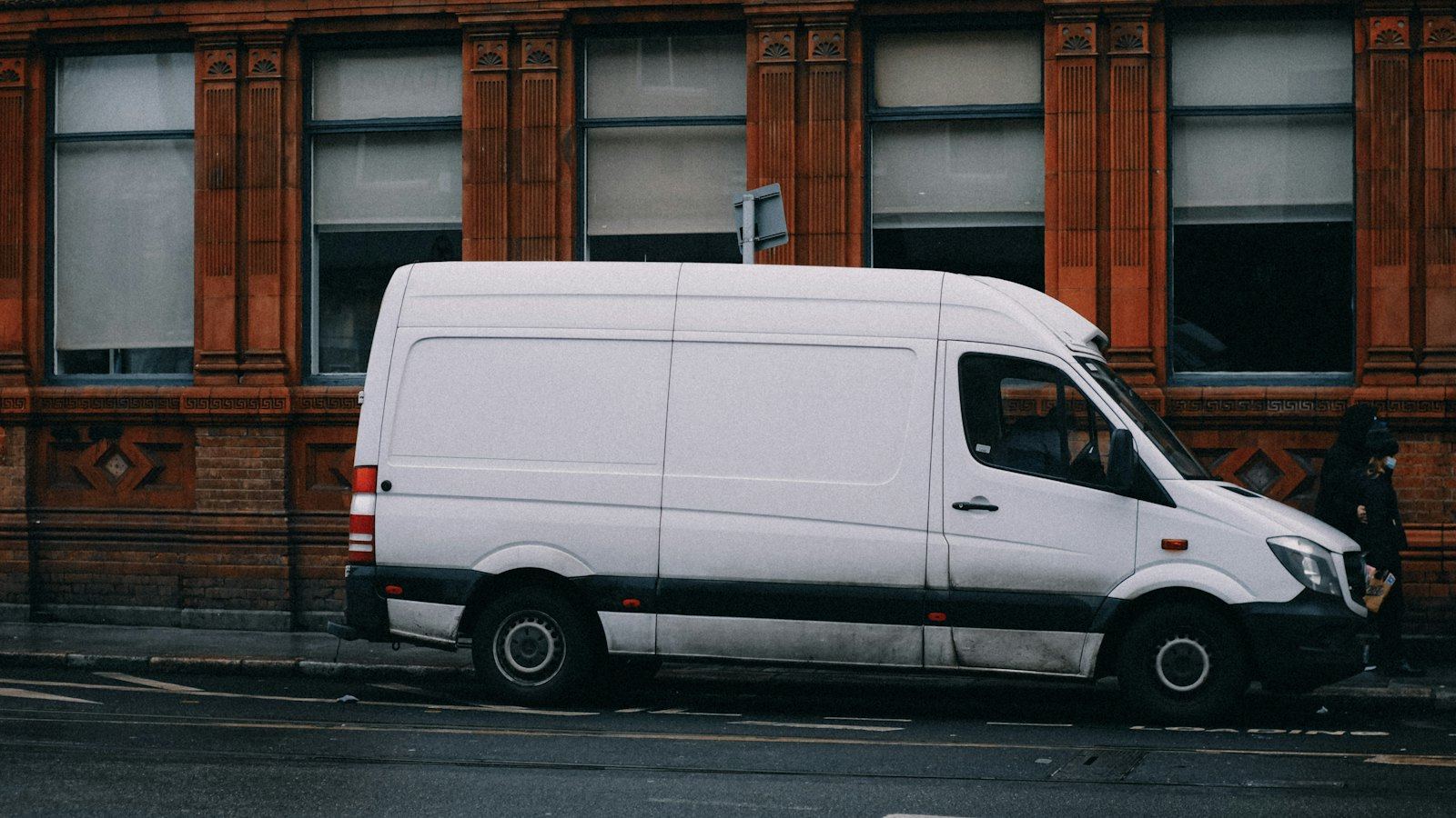 A white service van parked on a city street