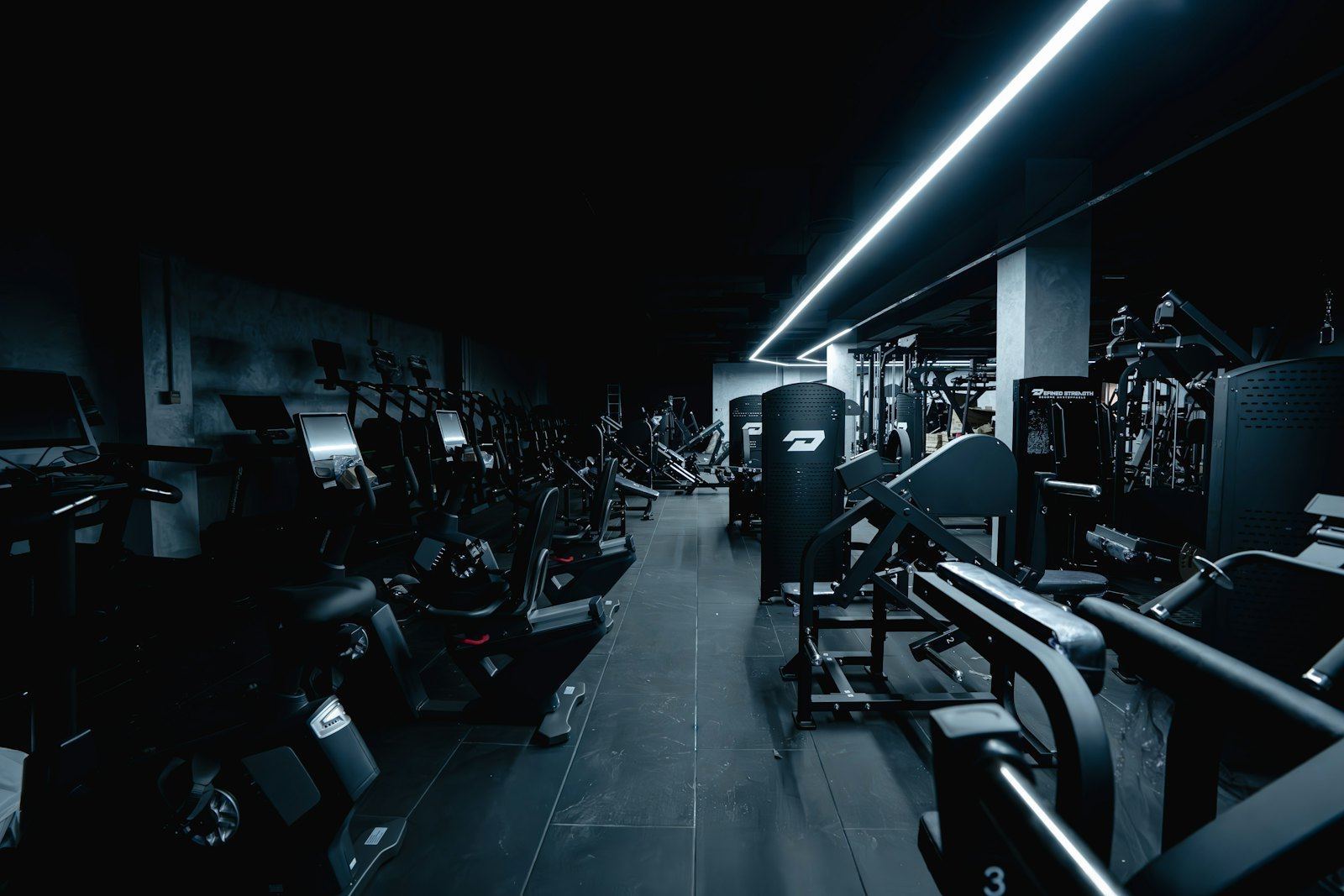 A dark gym floor lit by a single LED strip